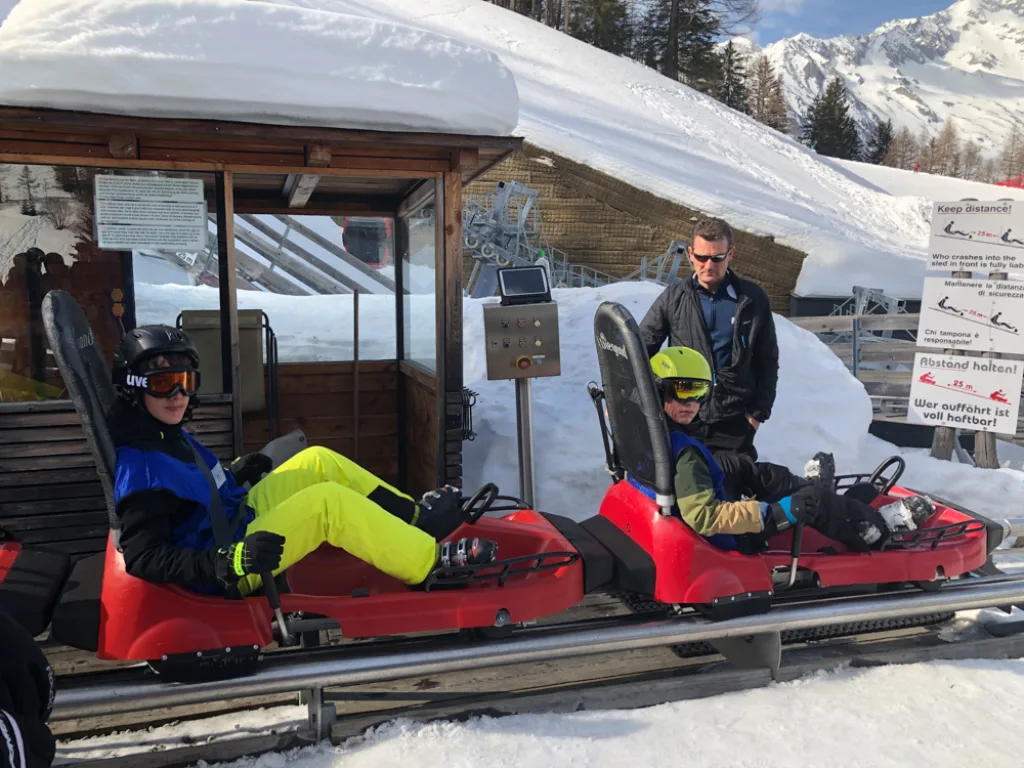 Jugendliche warten an der Station des Alpine Coasters.